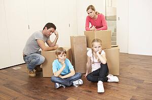 Young family looking upset among boxes