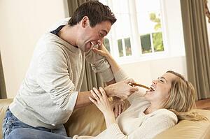 Young couple having fun laughing on sofa