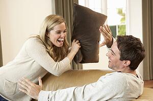 Young couple having fun laughing on sofa