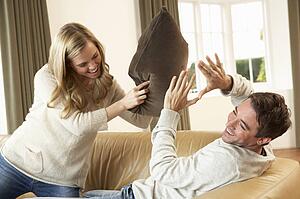 Young couple having fun laughing on sofa