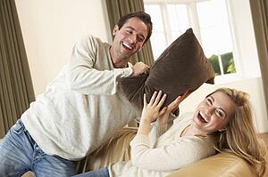 Young couple having fun laughing on sofa