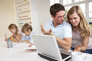 Young couple thinking and looking at a laptop computer