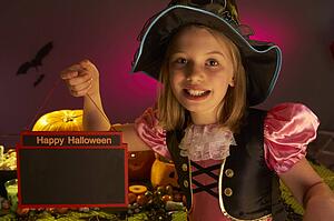 Halloween party with a child holding sign in hand