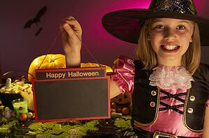Halloween party with a child holding sign in hand