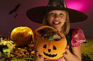 Halloween party with a child showing candy