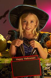 Halloween party with a child holding sign
