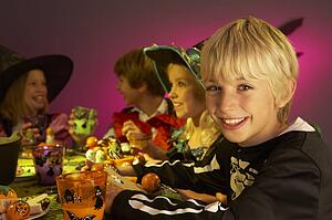 Halloween party with children having fun in fancy costumes
