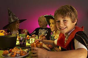 Halloween party with children having fun in fancy costumes