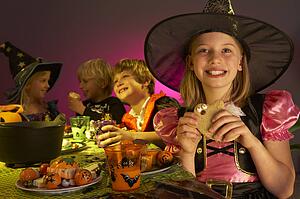 Halloween party with children having fun in fancy costumes