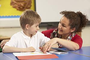 Schoolboy Studying In Classroom With Teacher