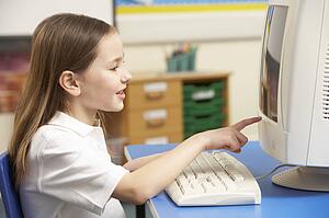 Schoolgirl In IT Class Using Computer