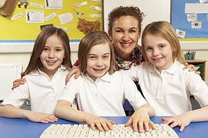 Schoolchildren in IT Class Using Computers With Female Teacher