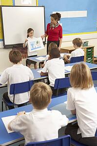 Schoolchildren Studying In Classroom With Teacher