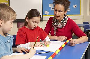 Schoolchildren Studying in classroom with teacher