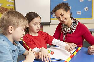Schoolchildren Studying in classroom with teacher