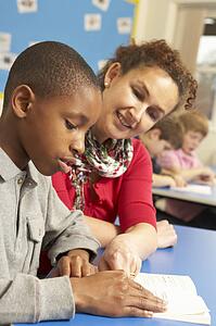 Schoolboy Studying In Classroom With Teacher