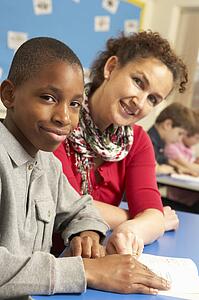 Schoolboy Studying In Classroom With Teacher