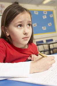 Stressed Schoolgirl Studying In Classroom