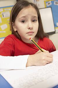 Stressed Schoolgirl Studying In Classroom