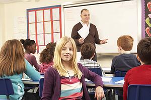 Schoolchildren Studying In Classroom With Teacher