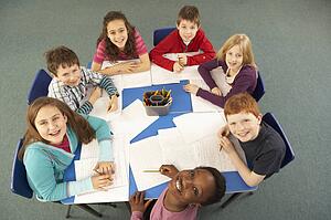 Overhead View Of Schoolchildren Working Together At Desk