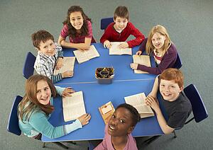 Overhead View Of Schoolchildren Working Together At Desk