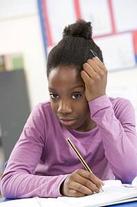 Stressed Schoolgirl Studying In Classroom