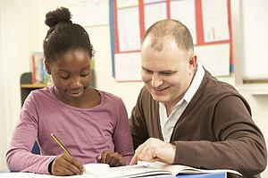 Female Pupil Studying in classroom with teacher