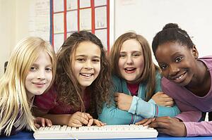 Group Of Schoolgirls In IT Class Using Computer
