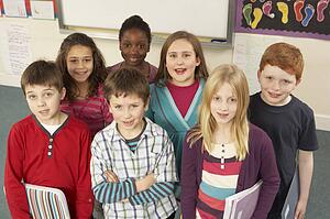 Portrait Of Schoolchildren Standing In Classroom