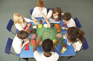 Overhead View Of Schoolchildren Working Together At Desk