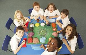 Overhead View Of Schoolchildren Working Together At Desk