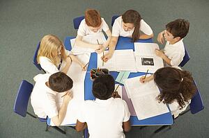 Overhead View Of Schoolchildren Working Together At Desk