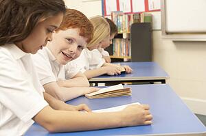 Group Of Children Reading Books In Classroom