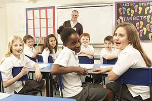 Schoolchildren Studying In Classroom With Teacher