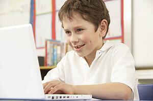 Schoolboy In IT Class Using Computer