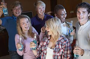 Group Of Teenage Friends Dancing And Drinking Alcohol