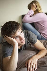 Teenage Couple In Bedroom After Argument