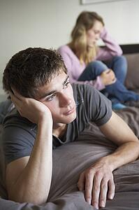 Teenage Couple In Bedroom After Argument