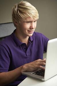 Teenage Boy Using Laptop At Home