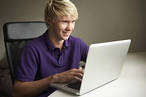 Teenage Boy Using Laptop At Home