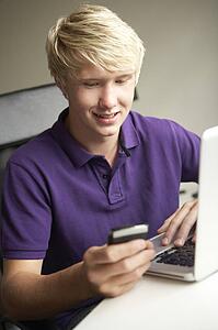 Teenage Boy Lying In Bedroom Drinking