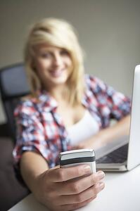 Teenage Girl Using Laptop And Mobile At Home