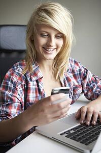 Teenage Girl Using Laptop And Mobile At Home