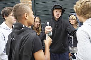 Group Of Threatening Teenagers Hanging Out Together Outside Drin