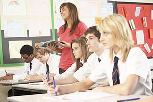 Teenage Students Studying In Classroom With Teacher