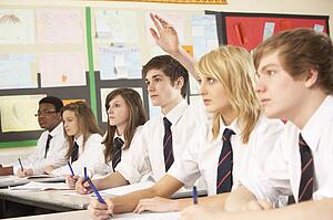 Teenage Student Answering Question Studying In Classroom