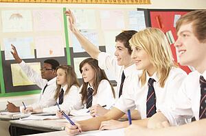 Teenage Student Answering Question Studying In Classroom