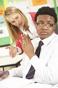 Teenage Student Refusing Help In Classroom From Teacher