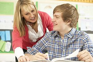 Male Teenage Student Studying In Classroom With Teacher